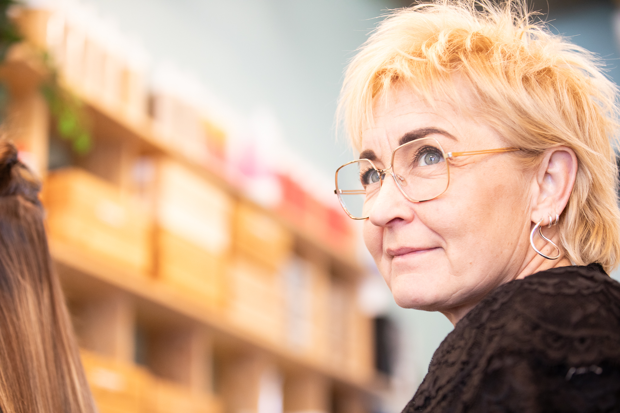 Maria Åberg vid produkthyllan i salongen